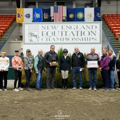 Group holding trophy before New England Equitation Championships banner